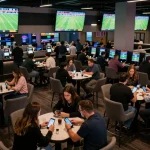 Socolive sports betting lounge with excited patrons placing bets on football matches